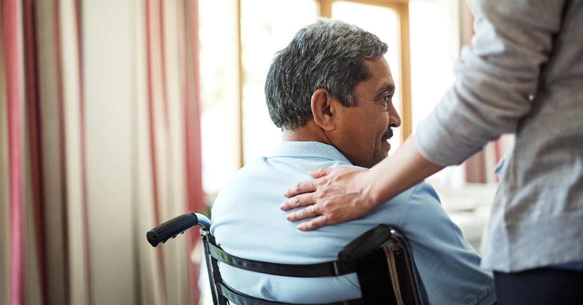 A caregiver comforting a man in a wheelchair, highlighting the importance of special needs planning.
