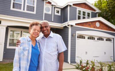 An Older Couple Stands In Front Of Their Home With Safety Features To Help Them Stay There Longer.