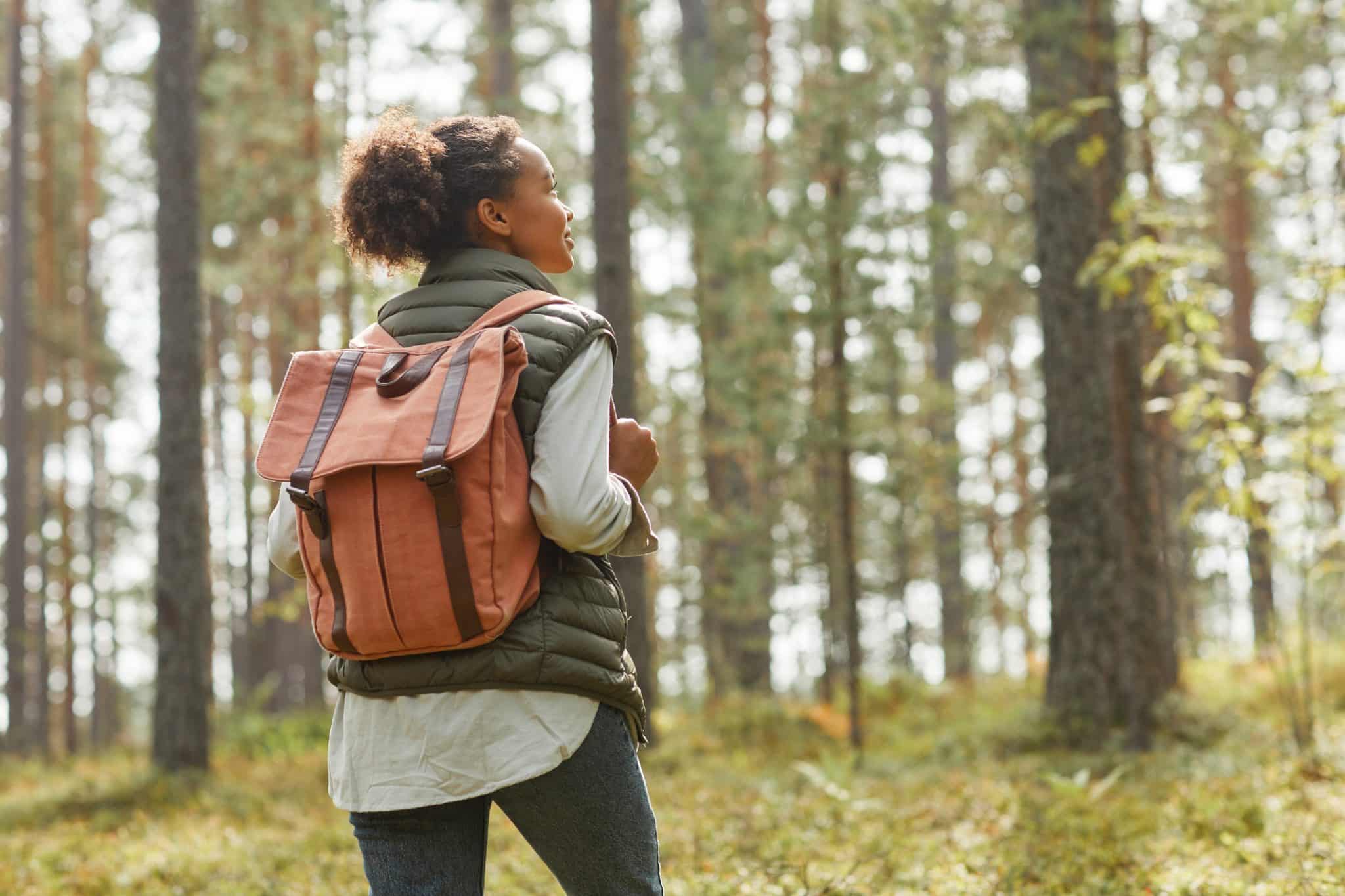A single woman on a hike enjoys her freedom while thinking about her future and her estate planning needs.