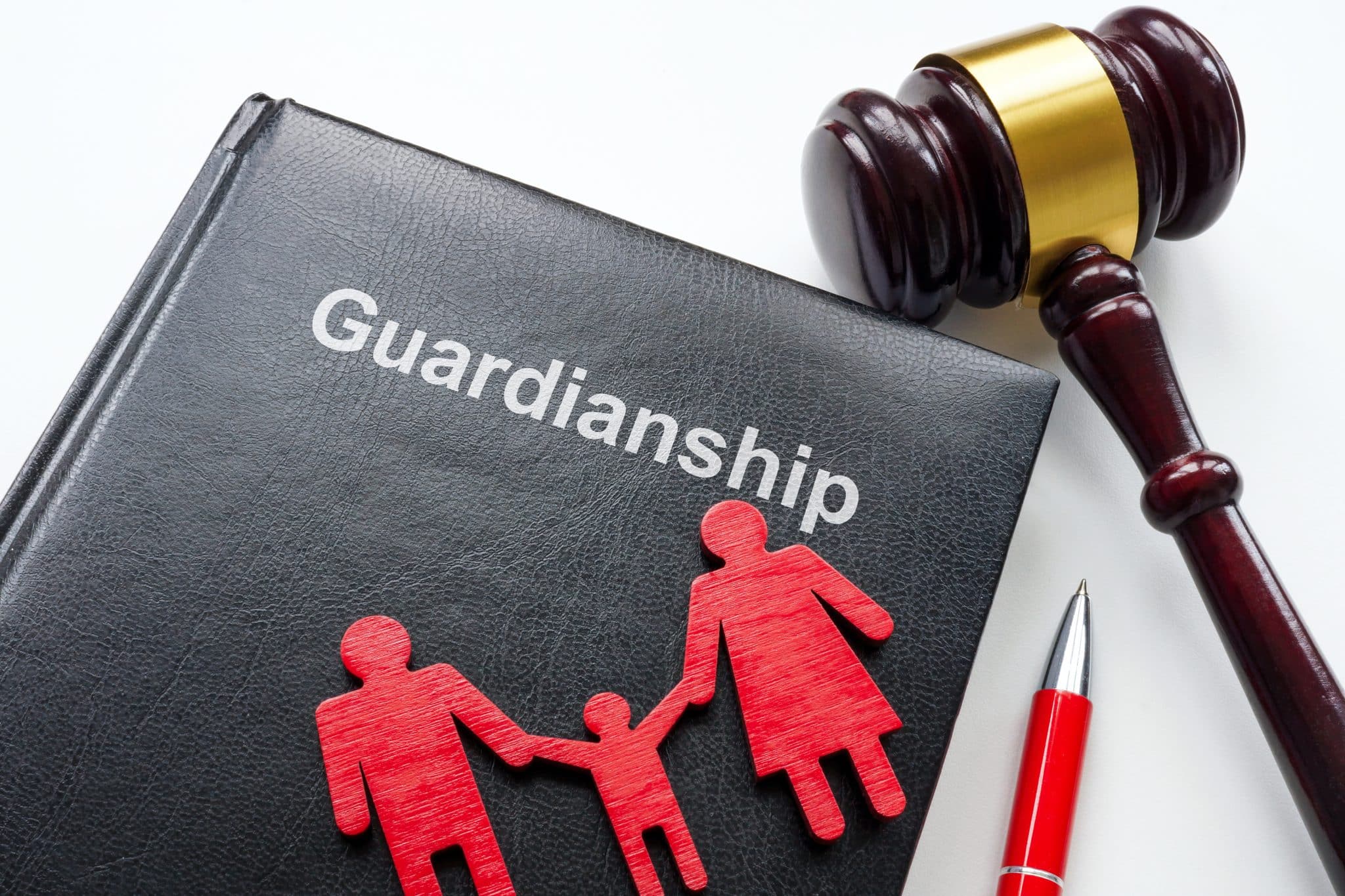 A notebook with the word “guardianship” written on it, next to a gavel, pen, and a small figure of a family, representing how the law handles choosing a guardian.