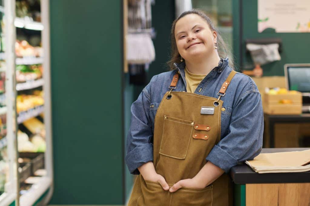 A woman with Down Syndrome at her job, where she maintains independence.