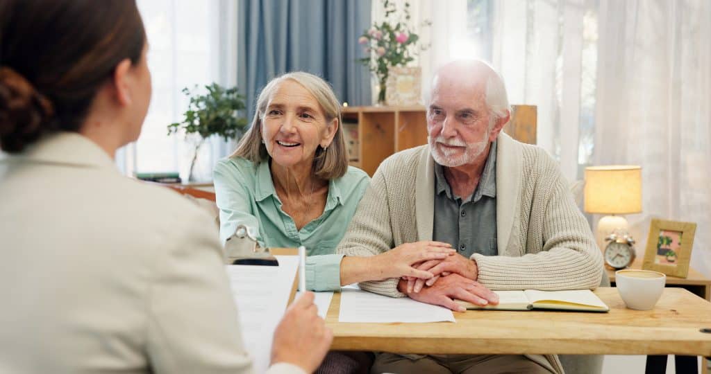 A senior couple sits with their lawyer to work on estate planning.